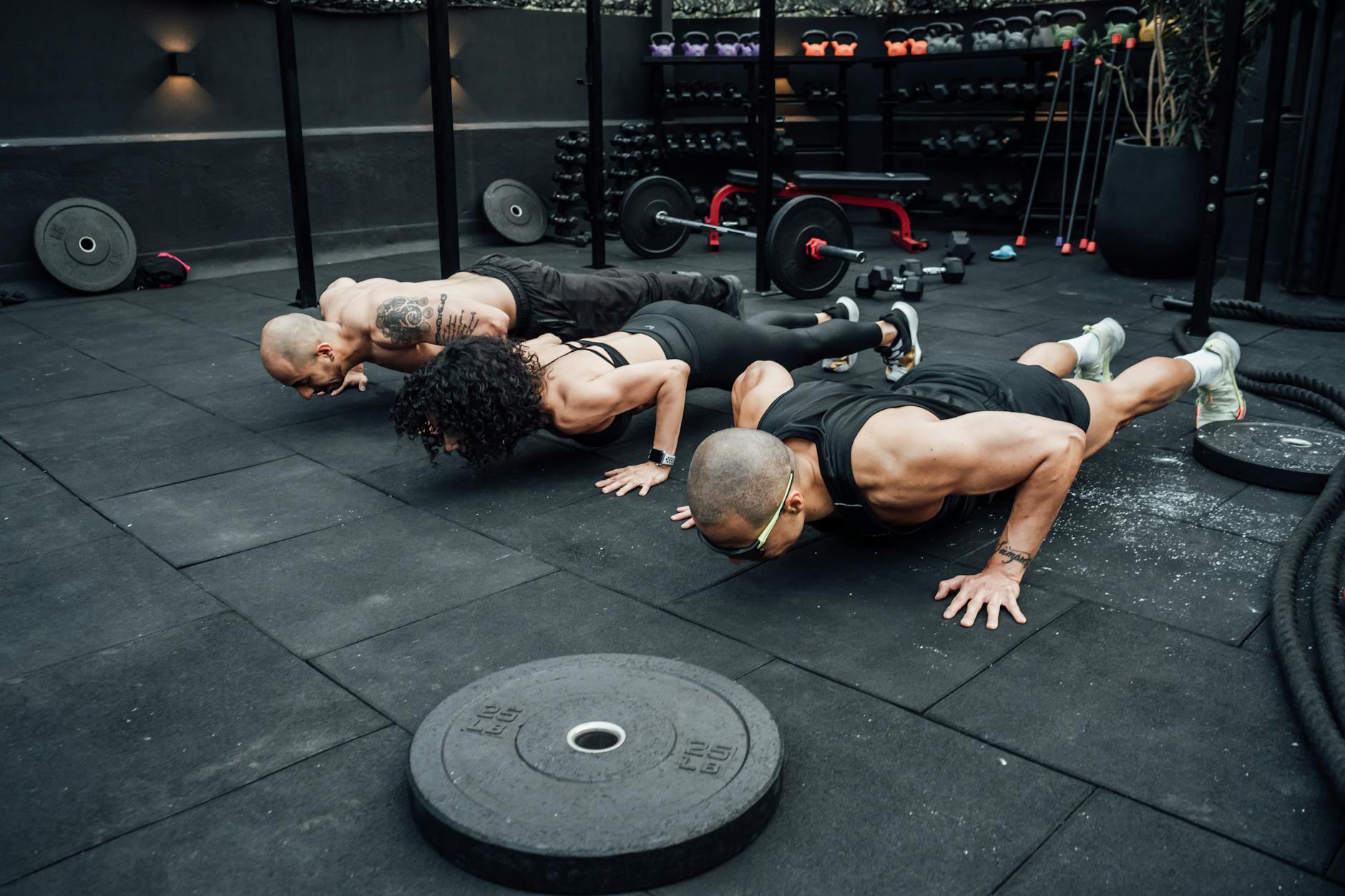 Fitness enthusiasts performing push-ups in a Mexico City gym. Emphasizing teamwork and strength.