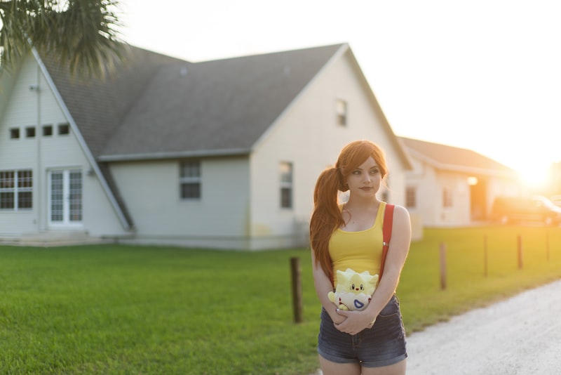 woman standing near white house during daytime